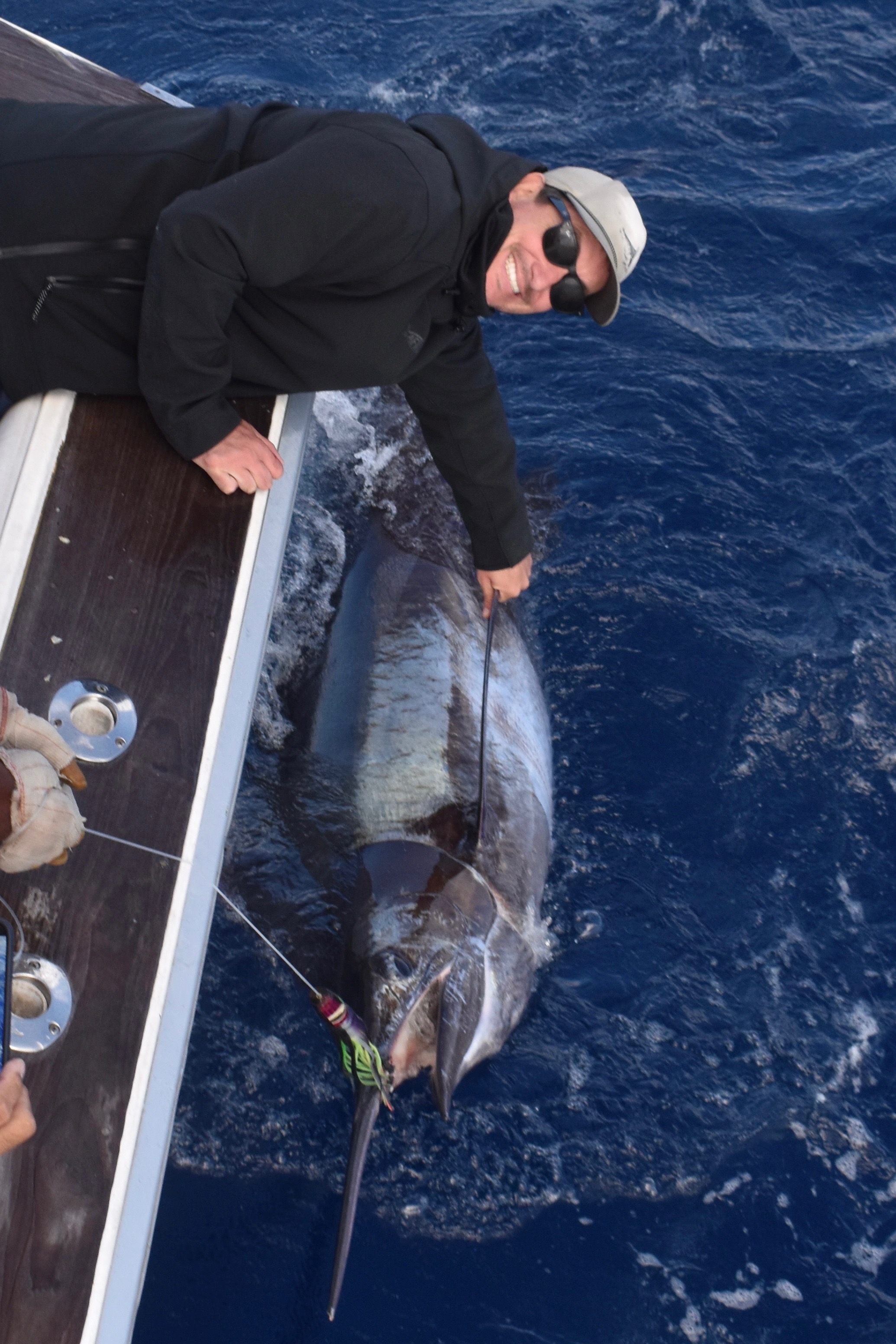An angler alongside a blue marlin at the boat in the Azores.