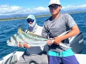 Two anglers holding a roosterfish inshore in Costa Rica