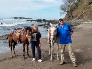 Two riders on horses along the Costa Rica shoreline