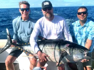 Three anglers posing with a large tuna offshore in Costa Rica