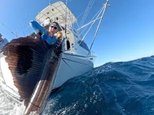 Excited angler holding a sailfish alongside the boat in Guatemala