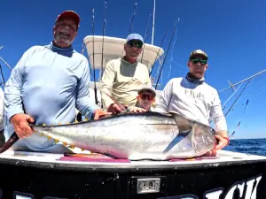 Three generations of anglers posing with a large tuna in Guatemala