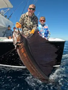 Family group with a sailfish alongside the boat in Guatemala