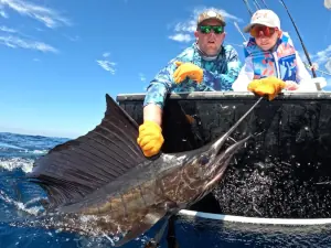 Two generations of anglers posing with a sailfish in Guatemala