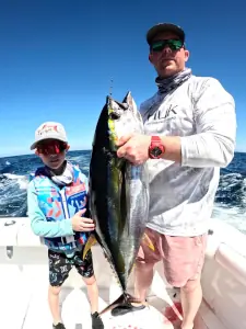 Two generations of anglers holding a tuna in Guatemala