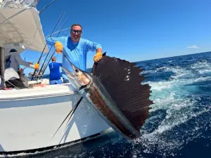 Angler with yellow gloves posing with another sailfish in Guatemala