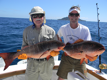 Two anglers holding two large Redfish caught in Panama