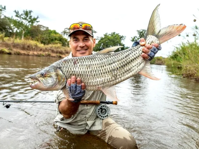 An excited angler holding a tigerfish in Tanzania