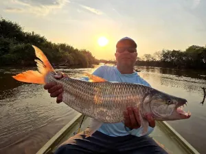 An angler showing a tigerfish at sunset in Tanzania